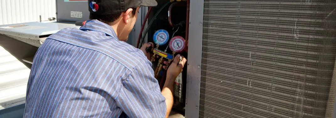 HVAC technician servicing a condenser unit in Smyrna